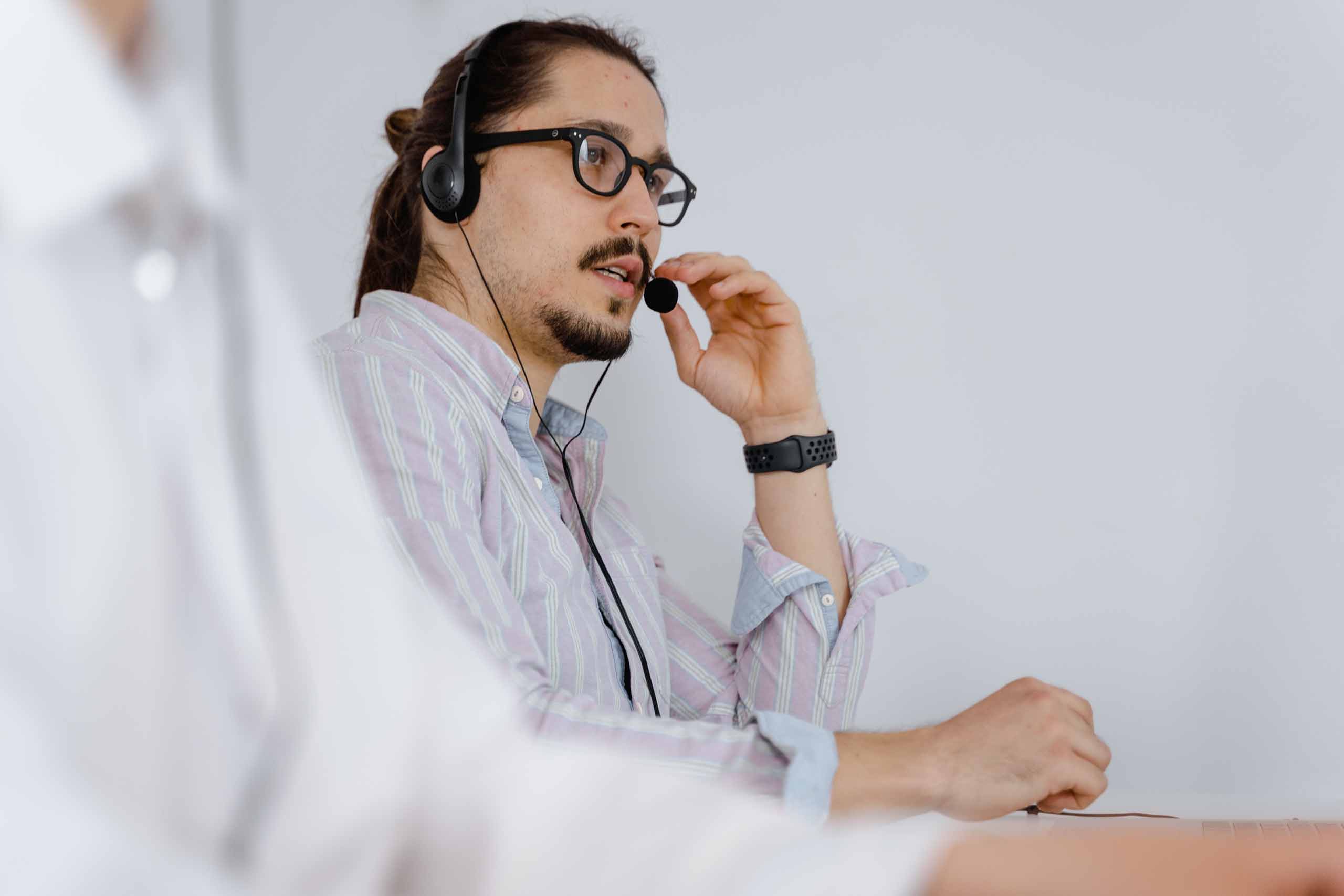 A customer service representative talking to someone through a telephone headset.
